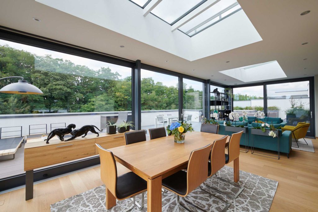 Jardin d'hiver - salon entièrement ouvert. Table à manger en bois massif. Vue sur la terrasse.
