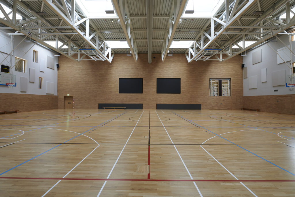 Salle de sport avec sol en parquet.