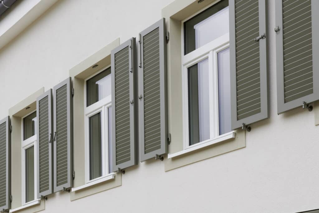 Fenêtres extérieures en bois blanc avec volets verts