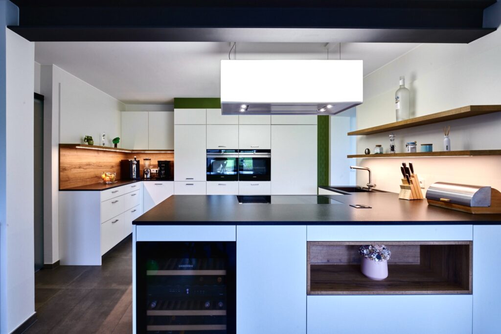 Grande cuisine lumineuse avec îlot de cuisson et hotte aspirante éclairée