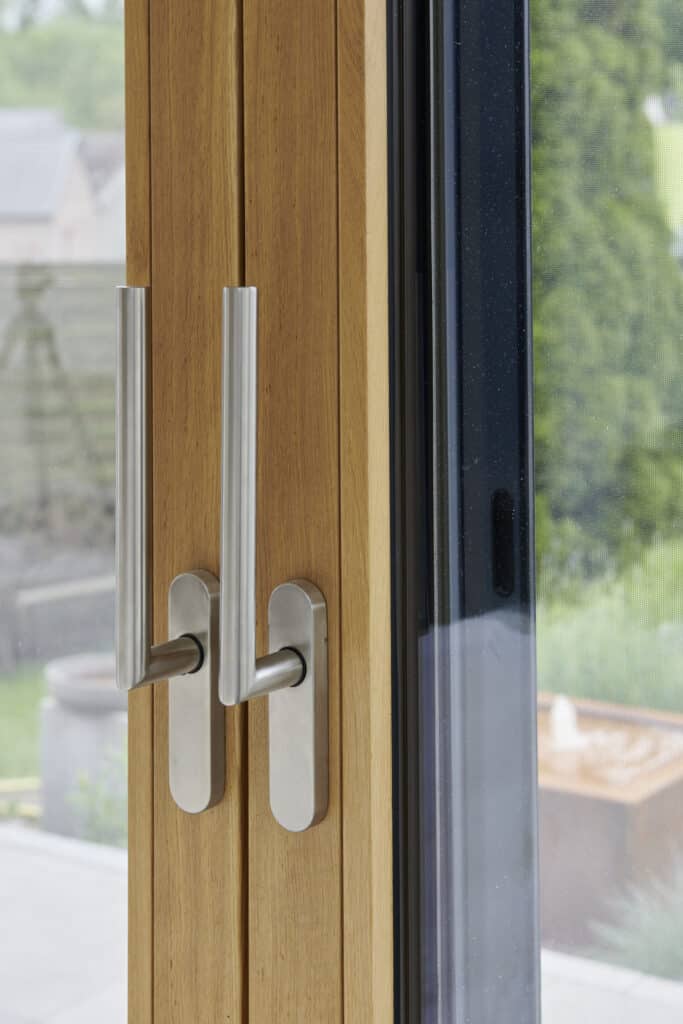 Nahaufnahme von Fenstergriffen. Fensterrahmen ist aus Holz. Fenstergriffe aus Inox.