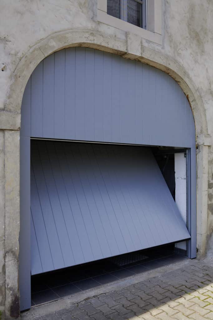Restauriertes Garagentor in hellblau lackiert.